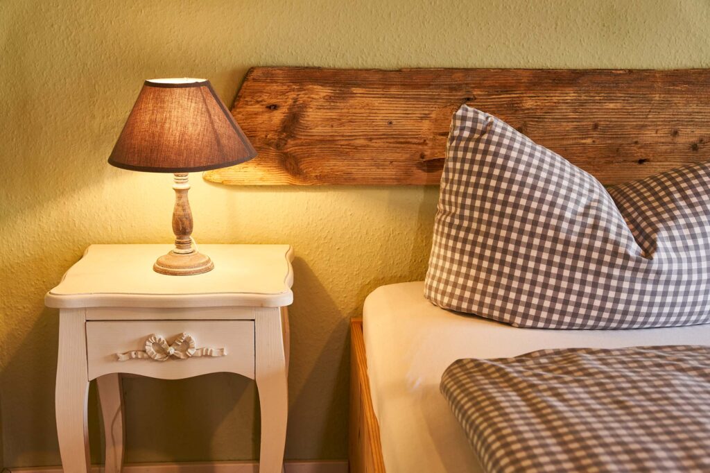 Nachtkästchen mit Lampe in der Pension Haus am Bach ARRIVEL